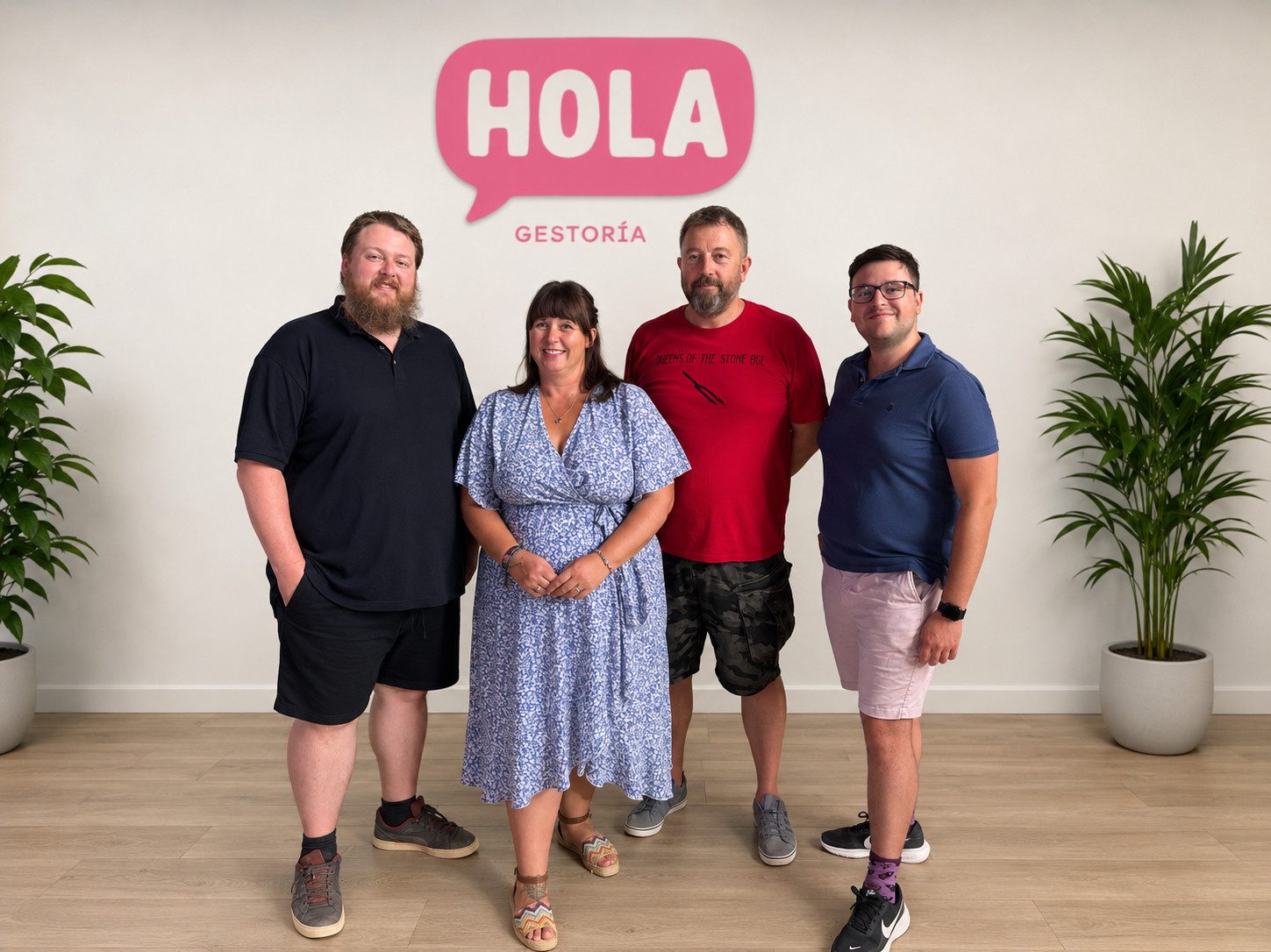 The Hola Gestoría team - Harry, Steph, Andy and Jose - in the office beneath the Hola Gestoría logo